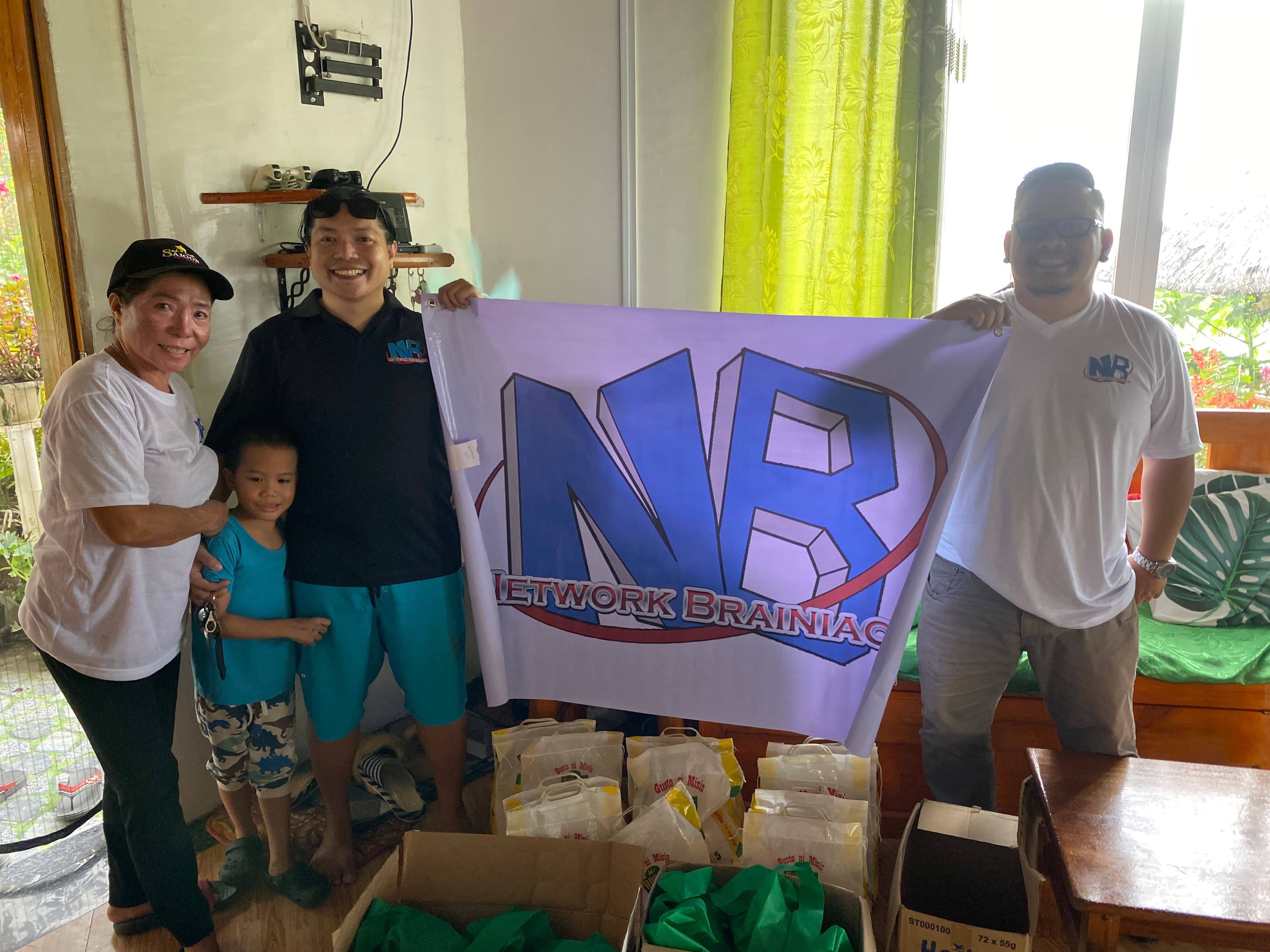 Team delivering care packages with the Network Brainiacs flag inside a home