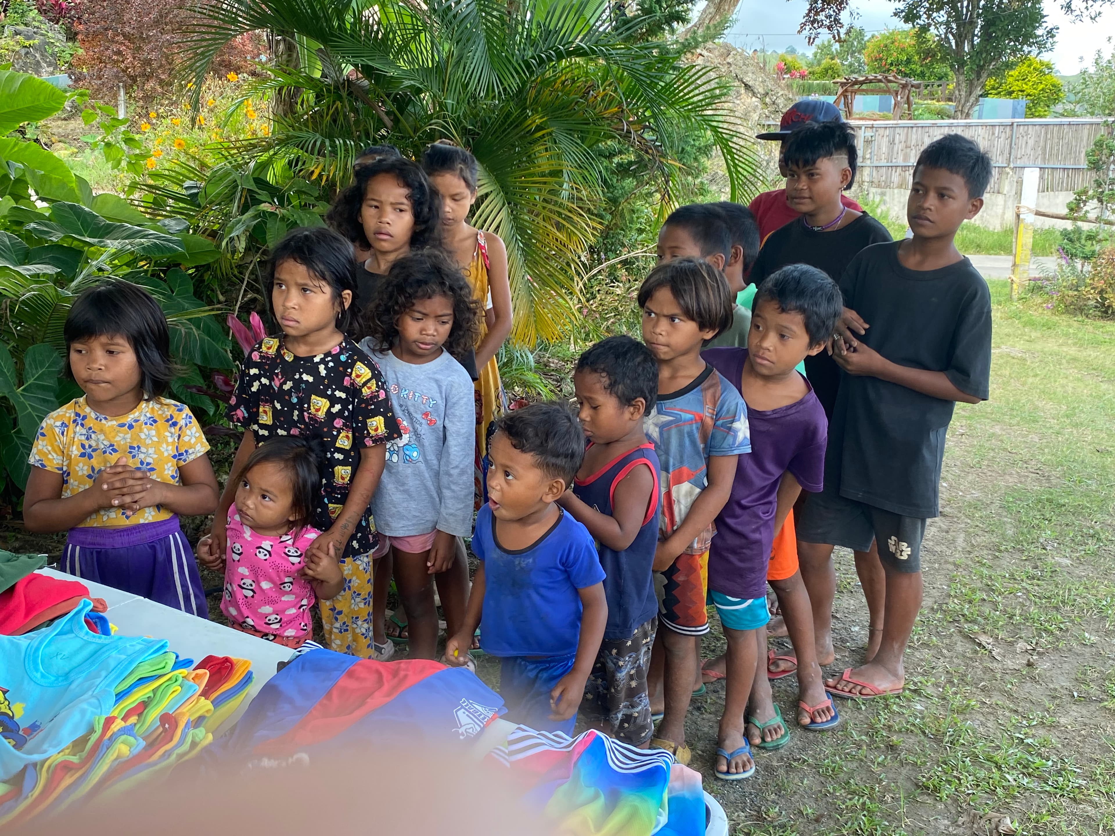 A line of children waiting their turn at the clothing table