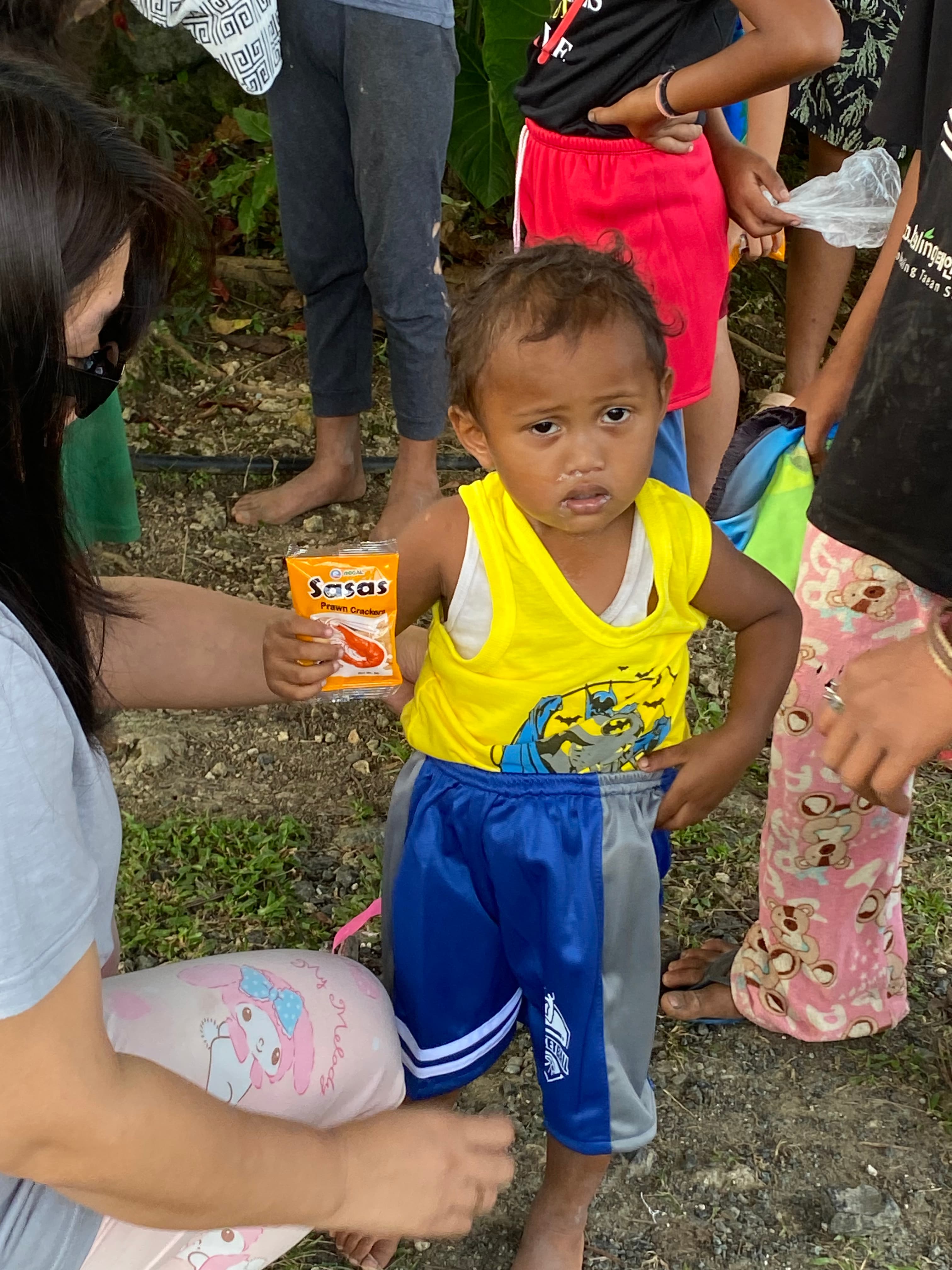 A toddler holding a pack of candy from the distribution