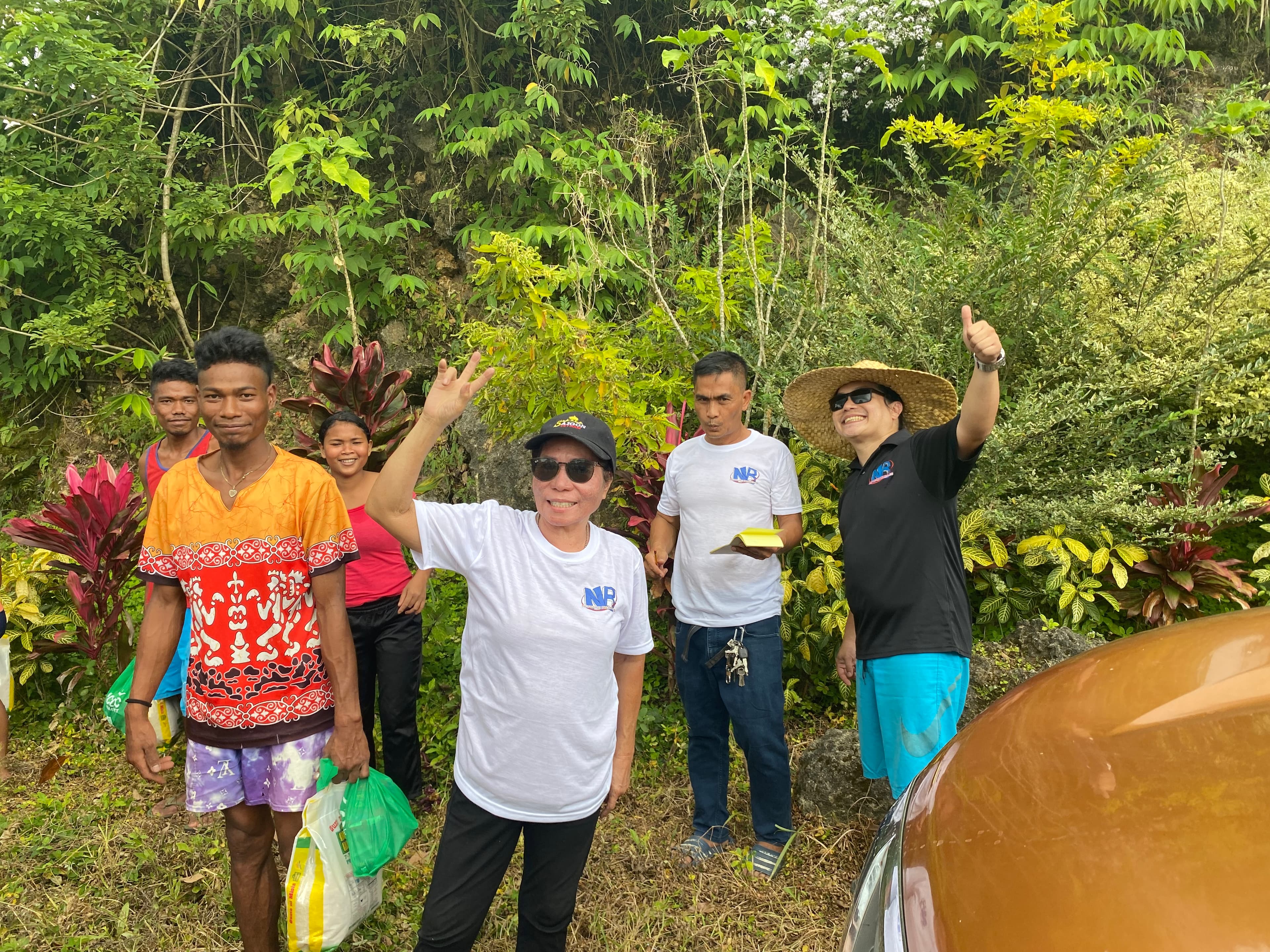 Team carrying supply bags up a mountain trail to the next family